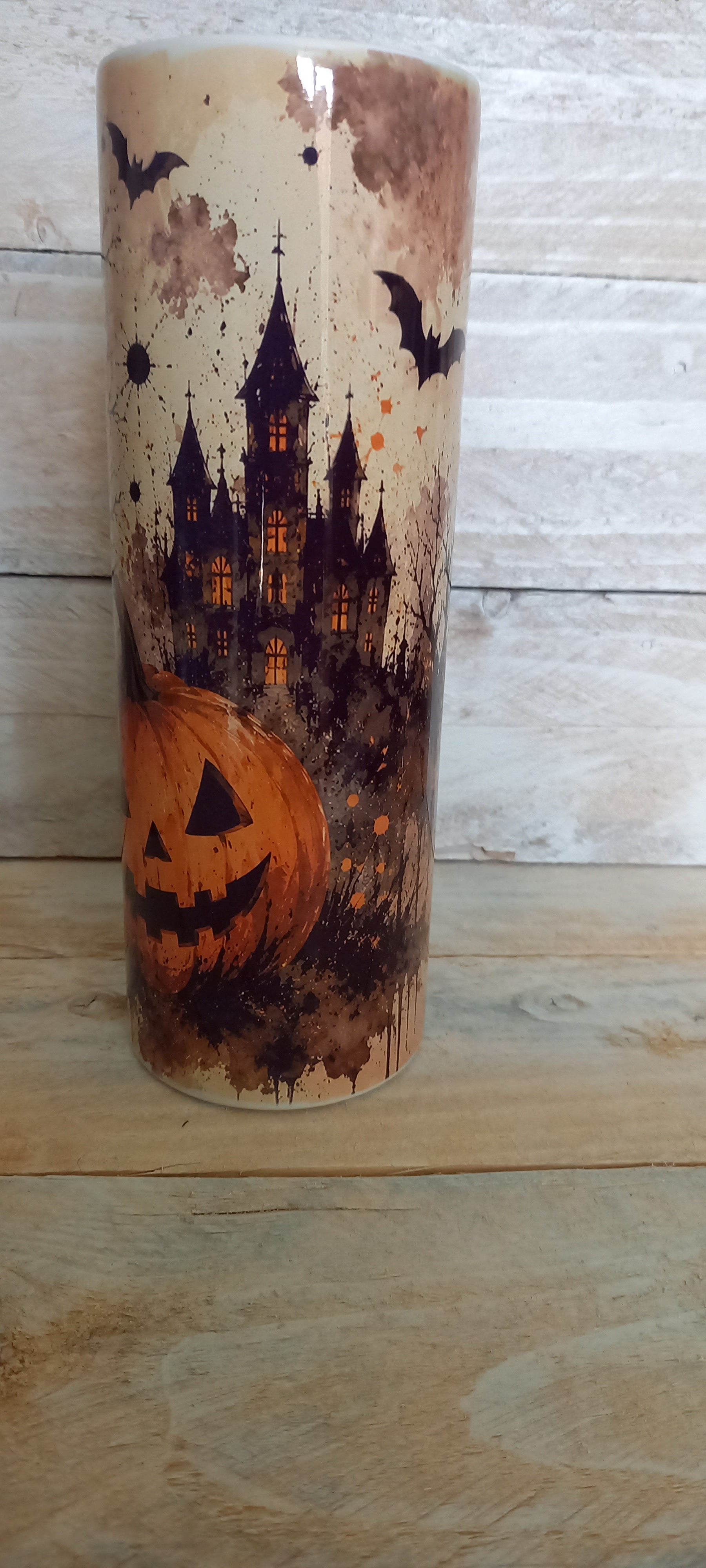 Stainless steel tumbler with haunted castle, jack-o-lantern and bats Halloween design on cream background