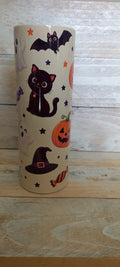Halloween stainless steel tumbler with cute icons including black cat, bat, pumpkin, ghost and witch hat on cream background